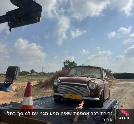 רכב ישן על גרר עם קונוס בטיחות